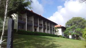 a building with a lawn in front of it at Flat Condomínio Hotel Fazenda Gravatá Monte Castelo in Gravatá