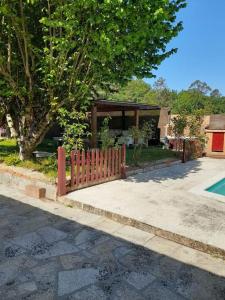 una recinzione di fronte a una casa con piscina di Agradable casa rural en Galicia ad A Estrada