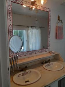 un bagno con due lavandini e un grande specchio di Agradable casa rural en Galicia ad A Estrada