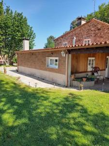 uma casa de tijolos com um pátio e um quintal em Agradable casa rural en Galicia em A Estrada