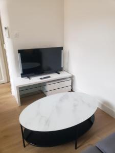 a white coffee table in a living room with a tv at T2 neuf tout équipé, climatisé in Marseille