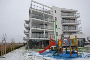 un edificio de apartamentos con un parque infantil delante de él en Westin House Resort Kołobrzeg Apartament DELUX en Kołobrzeg