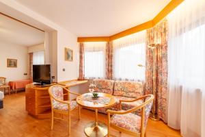 ein Wohnzimmer mit einem Tisch und einem Sofa in der Unterkunft Frühstücks-Hotel Olympia in Dorf Tirol