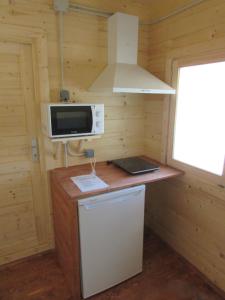 a small kitchen with a microwave and a stove at Camping Hoces de Mira in Mira
