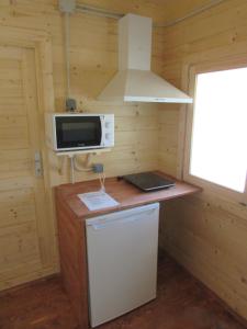 Una pequeña cocina con microondas y estufa. en Camping Hoces de Mira, en Mira