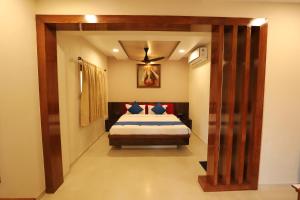 ein Schlafzimmer mit einem Bett und einem großen Holztür in der Unterkunft Raaj Resort in Panvel