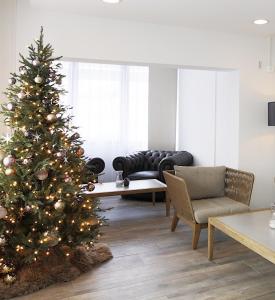 un árbol de Navidad en una sala de estar con sofá en Hotel Work Life Residence am Bahnhof, en Winterthur