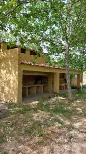 un edificio con un árbol delante en Camping Hoces de Mira, en Mira