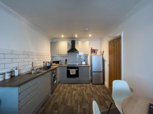 a kitchen with a sink and a refrigerator at The Bridge Apartments in Lowestoft