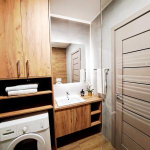 a bathroom with a washing machine and a sink at Apartman 49 in Subotica