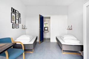 2 Betten in einem Zimmer mit Tisch und Stühlen in der Unterkunft Danhostel Rønde in Rønde