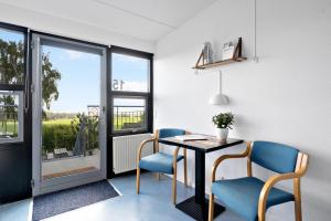 Zimmer mit einem Tisch, 2 Stühlen und einem Fenster in der Unterkunft Danhostel Rønde in Rønde