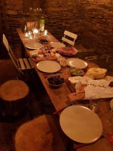 un lungo tavolo in legno con piatti bianchi di La Légende - Gîte dans un quartier pittoresque a Bouillon