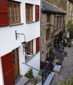 a building with red doors and a basketball hoop at La Légende - Gîte dans un quartier pittoresque in Bouillon