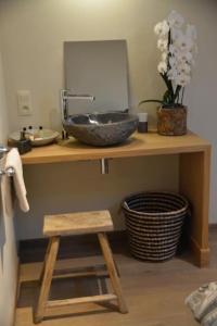 een badkamerbar met een wastafel en een kruk bij La Légende - Gîte dans un quartier pittoresque in Bouillon