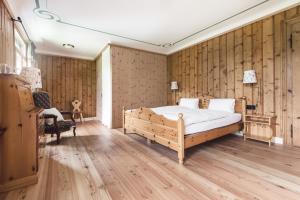a bedroom with a bed and a wooden wall at Hotel Fex in Sils Maria
