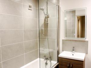 a bathroom with a shower and a sink at The Bridge Apartments in Lowestoft