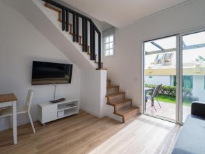 a living room with a staircase with a flat screen tv at Bungalow GARMAS in Maspalomas