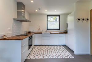 a kitchen with white cabinets and a tile floor at Larraetxea in Isla Becoa