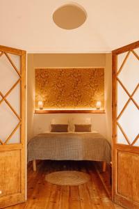 1 dormitorio con 1 cama en una habitación con suelo de madera en Gîte Superbe L'Ecurie XIXème, en Sallèles-dʼAude