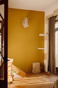 Habitación con pared amarilla y suelo de madera. en Gîte Superbe L'Ecurie XIXème, en Sallèles-dʼAude