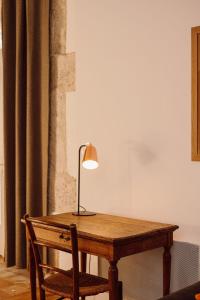 una mesa de madera con una lámpara y una silla en Gîte Superbe L'Ecurie XIXème, en Sallèles-dʼAude
