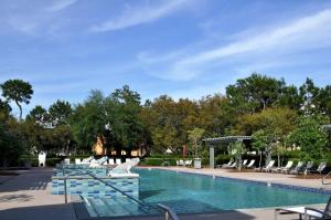 una piscina con sillas azules y una piscina en Ave 30A by Coastal Dreamin, en Santa Rosa Beach