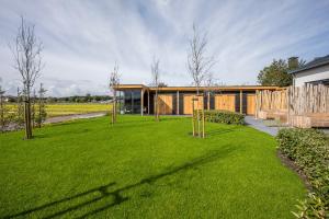 a house with a green lawn in front of it at Holiday Apartment Zee in Noordwijk