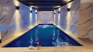 Una piscina de agua con una botella de vino. en Elven Hotel, en Jerusalén