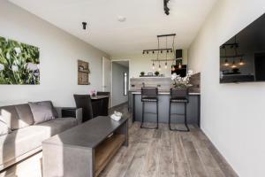 a kitchen and living room with a couch and a table at Holiday Apartment Zee in Noordwijk