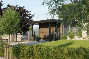 una casa con cenador en un patio en Wellness Lodge Ruigenhoek 13A - Sauna, Jacuzzi ! en De Zilk
