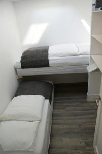 2 camas en una habitación con sábanas y almohadas blancas en Wellness Lodge Ruigenhoek 13A - Sauna, Jacuzzi ! en De Zilk