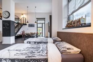 two beds in a room with a clock on the wall at Loft Casa Facco in Bocenago