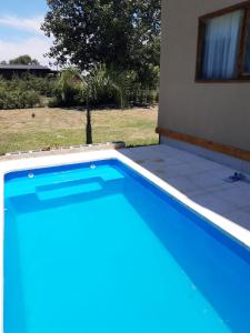 a large blue swimming pool next to a house at CARELHUE GUAZU 1 in Villa Paranacito