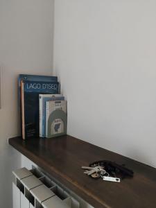 uno scaffale con un libro, una scatola e le chiavi di La Mansarda sul Lago a Lovere