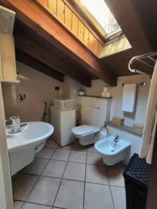 bagno con 2 lavandini, servizi igienici e lucernario di La Mansarda sul Lago a Lovere