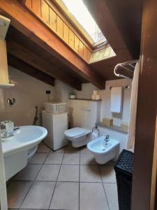 La salle de bains est pourvue de 2 lavabos, de toilettes et d'une fenêtre. dans l'établissement La Mansarda sul Lago, à Lovere
