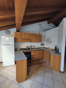 una cucina con armadi in legno e frigorifero bianco di La Mansarda sul Lago a Lovere