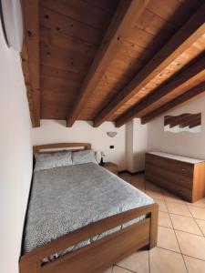 una camera con letto e soffitti in legno di La Mansarda sul Lago a Lovere