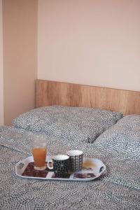 a tray with two cups and a drink on a bed at Zlatibor Apartman Kraljev trg in Zlatibor