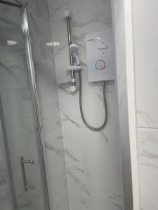 W łazience z przeszklonymi drzwiami znajduje się prysznic. w obiekcie London Studios w Londynie