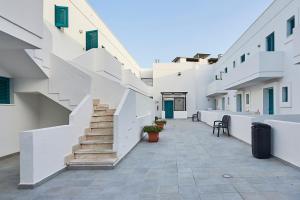 korytarz białych budynków ze schodami i klatką schodową w obiekcie Costa del Salento - CDSHotels w mieście Lido Marini
