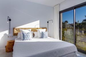 een witte slaapkamer met een groot bed en een groot raam bij 3009 - Luxurious new villa in quiet area in Costa de la Calma in Costa de la Calma