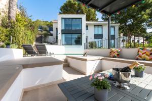 un patio con tavolo, sedie e una casa di 3009 - Luxurious new villa in quiet area in Costa de la Calma a Costa de la Calma