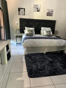 een slaapkamer met een groot bed met een zwart hoofdeinde bij Mihandzu Guest House in Hazyview