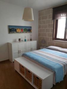 1 dormitorio con cama, mesa y ventana en Appartamento indipendente, en San Pietro Vernotico