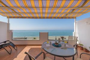 WintowinRentals Amazing Front Sea View & Relax في توري دي بيناغالبون: غرفة طعام مع طاولة وإطلالة على المحيط