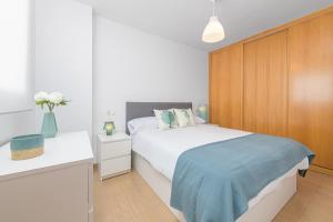 een slaapkamer met een wit bed en een houten muur bij WintowinRentals Amazing Front Sea View & Relax in Torre de Benagalbón