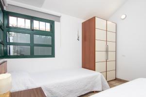 1 dormitorio con 2 camas y ventana en Bungalow Deluxe Las Palomas Maspalomas en Maspalomas