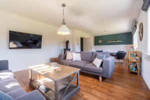 a living room with a couch and a table at Haus Perle in Oevenum